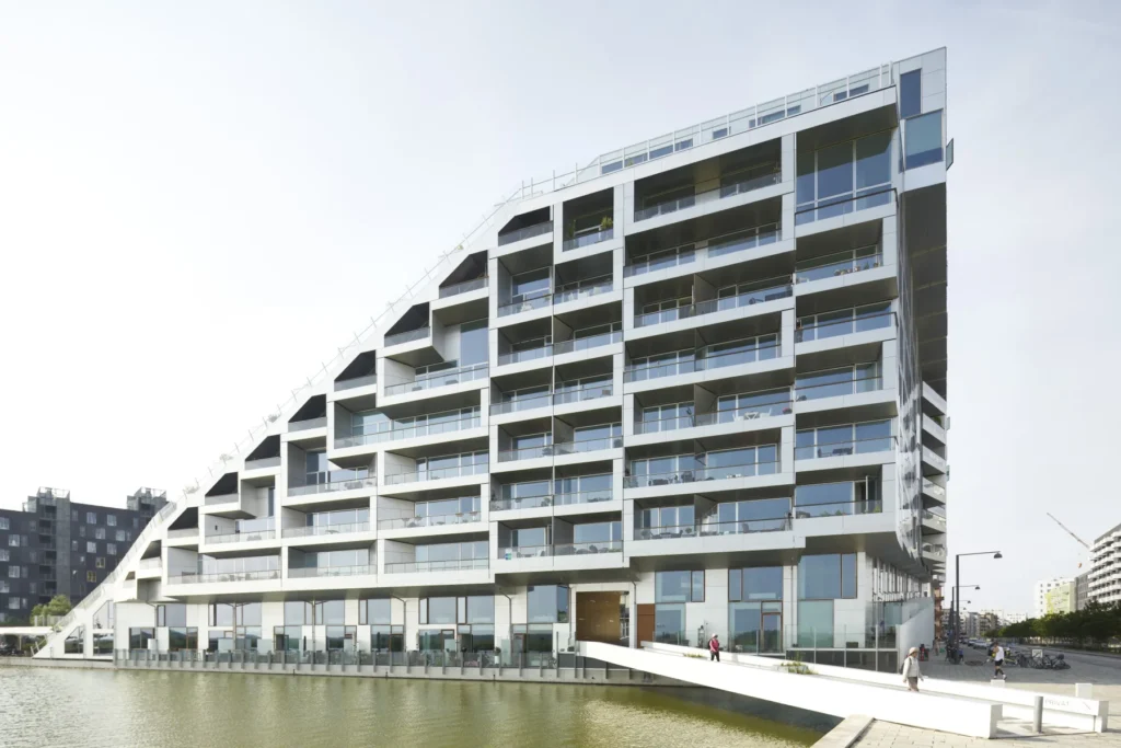 Residents walking on the elevated promenade of the 8 House by BIG