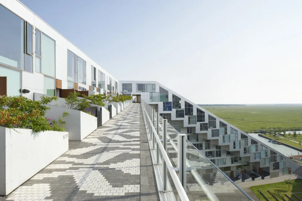 Patterned paving on the promenade path of the 8 House in Ørestad, Copenhagen with green fields beyond