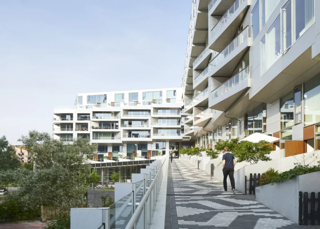 Residents walking on the elevated promenade of the 8 House by BIG