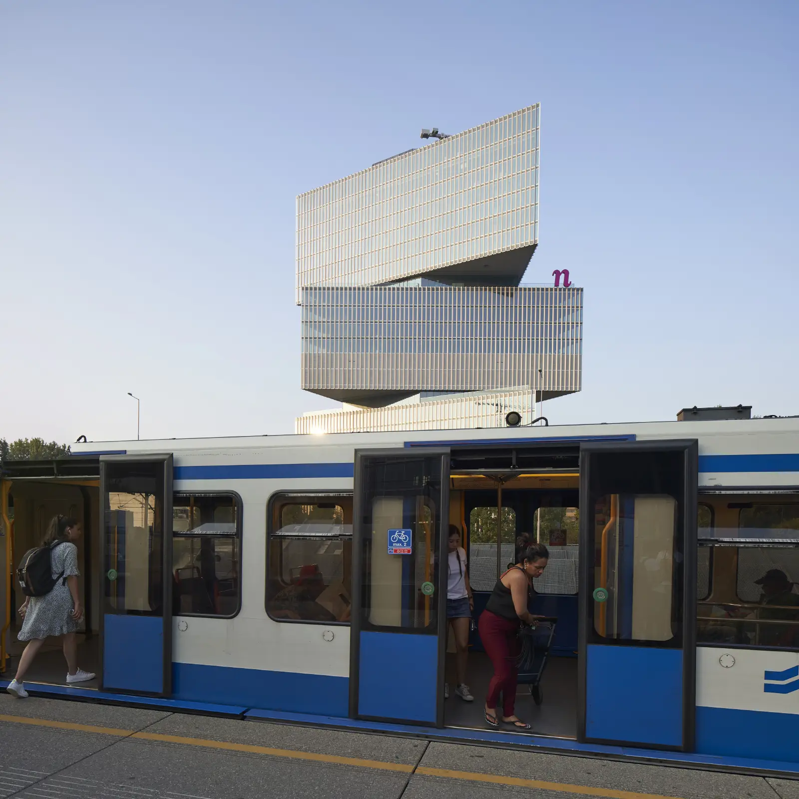 woman entering train at Amsterdam RAI with Rem Koolhaas nHow Hotel by OMA in the background