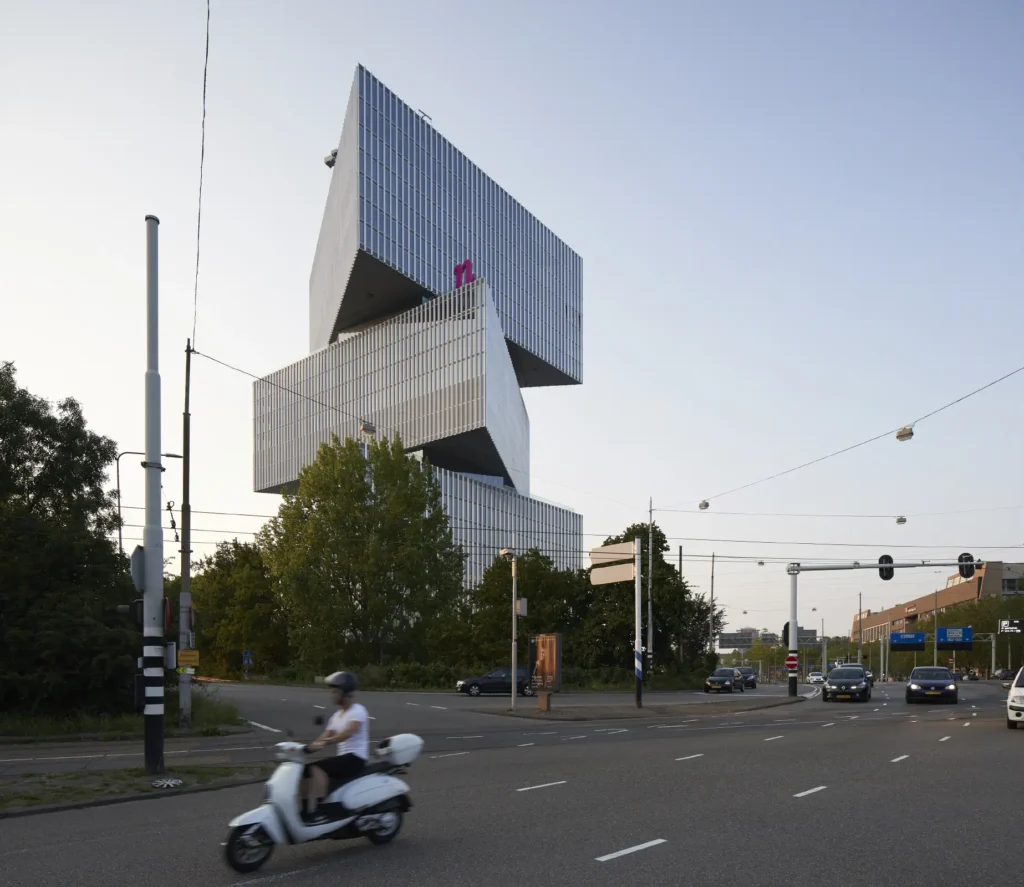 Motorcyclist and cars on road with nHow hotel by OMA in background Amsterdam