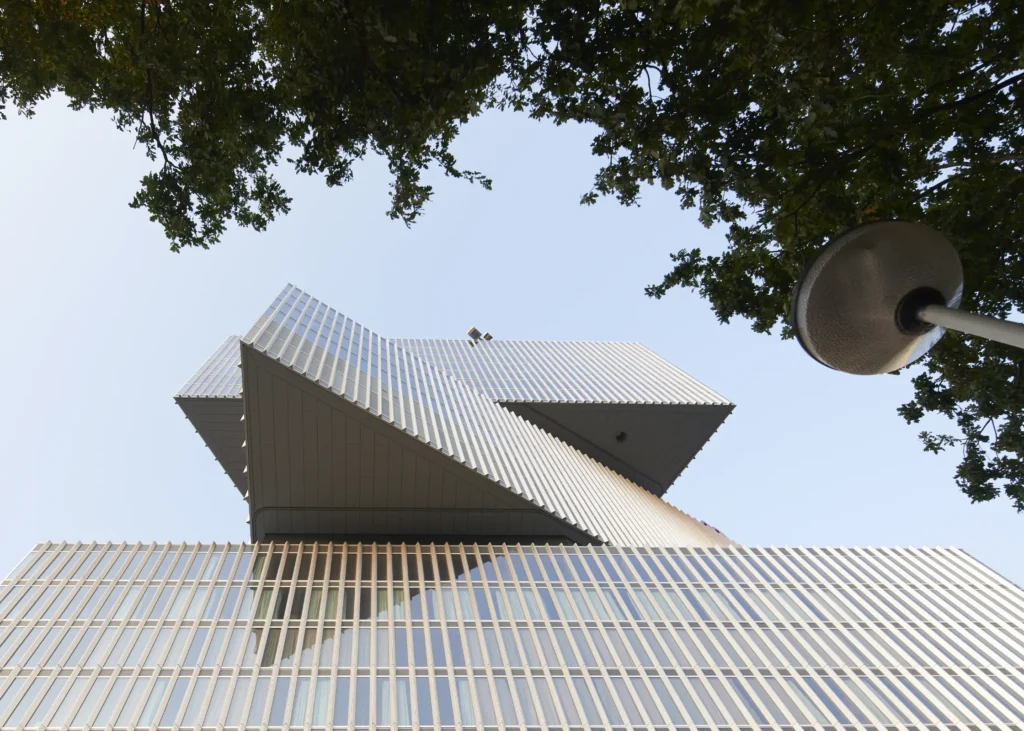 Close-up of stacked cantilevered volumes and glass facade at nHow Amsterdam RAI Hotel