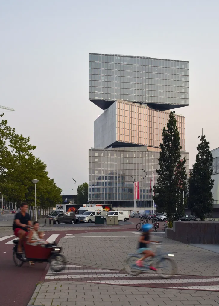 Full view of nHow hotel RAI showing shifted metal-clad volumes against evening sky in Amsterdam
