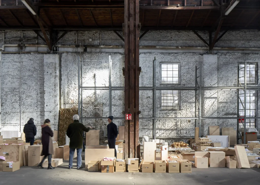 People standing among rows of architectural models in warehouse for Revolutions of Choice