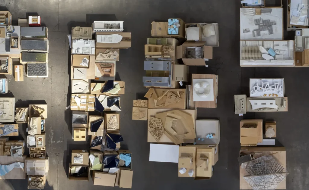 Bird's-eye view of boxed architectural models on pallets during exhibition preparation