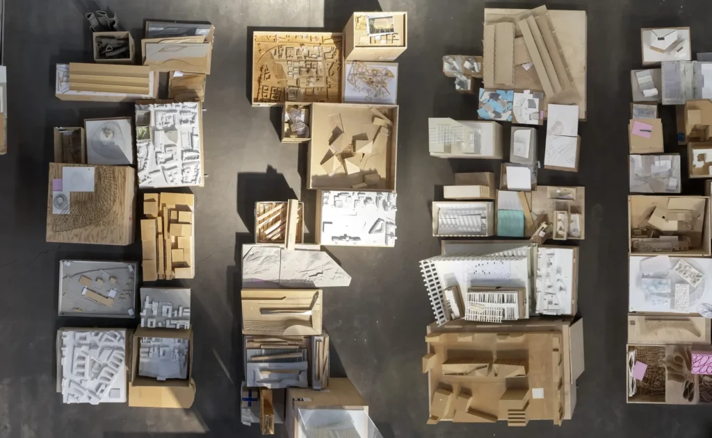 Close-up overhead view of timber and plaster architectural models grouped by scale