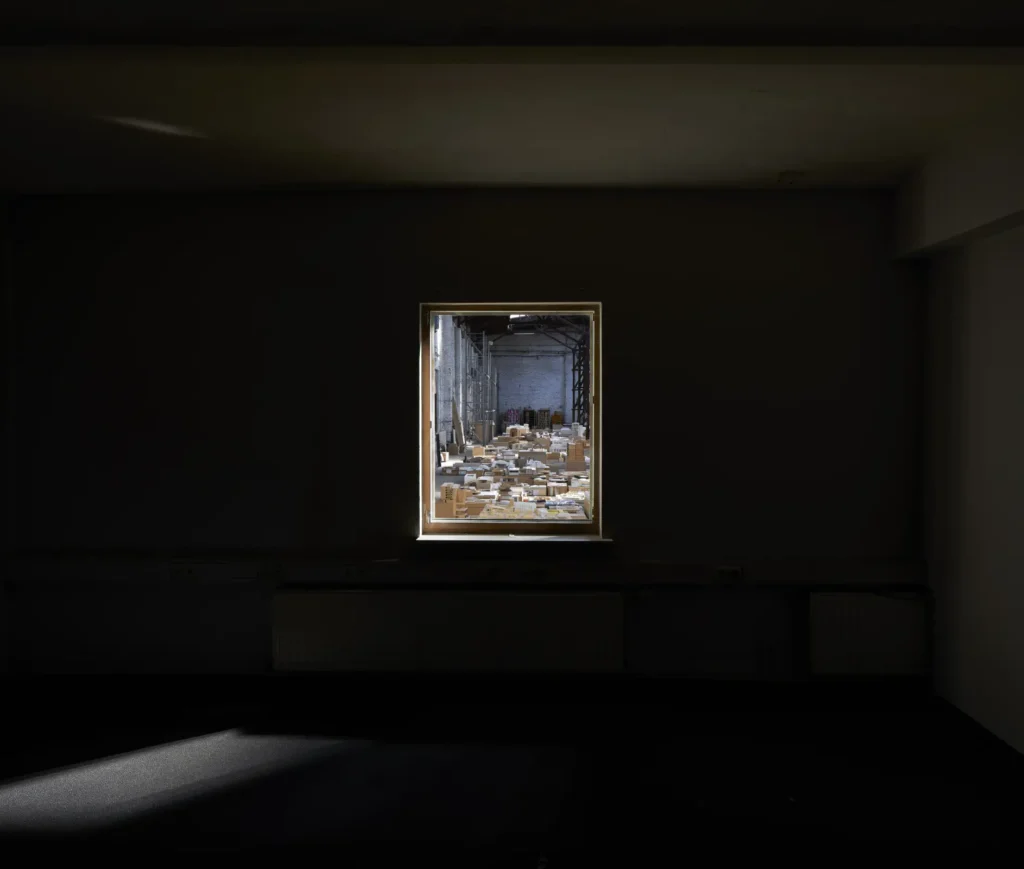 Dark room with window looking at models in warehouse for the exhibition Revolutions of Choice at Haus am Waldsee Berlin