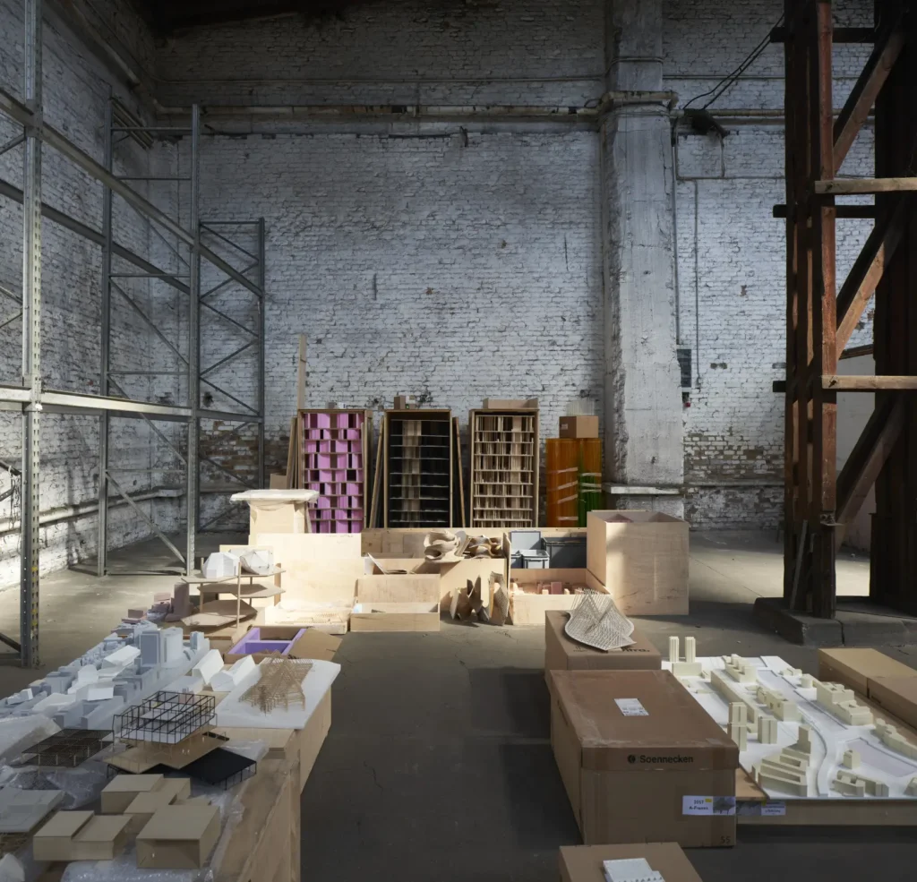 Architectural models with exposed brick wall behind in warehouse for Revolutions of Choice exhibition