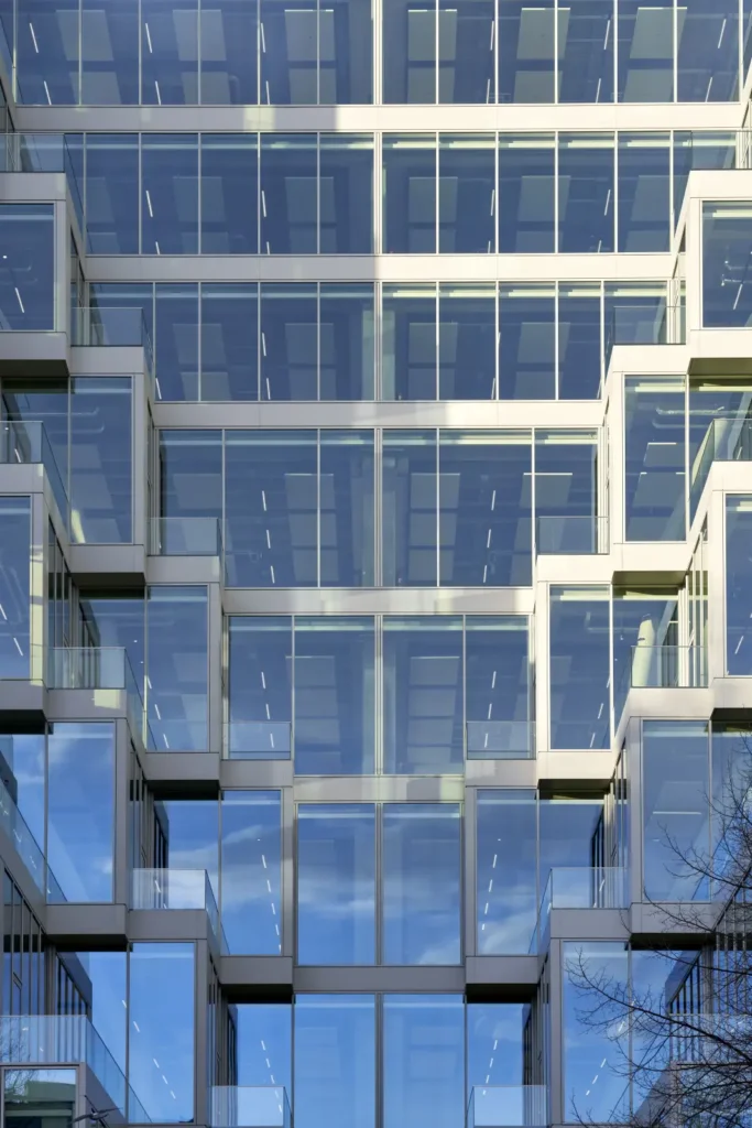 Geometric glass facade pattern reflecting sky at UP! Berlin by Jasper Architects