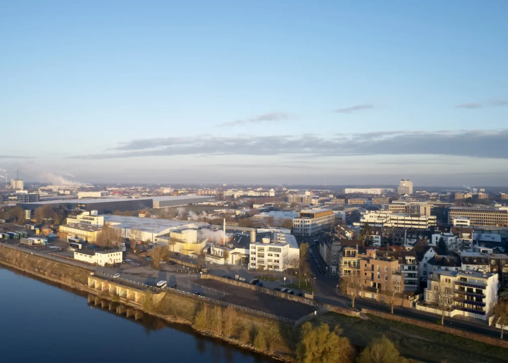 Elevated view of the Werft16 office complex floating golden in the morning light above Düsseldorf with Rhine
