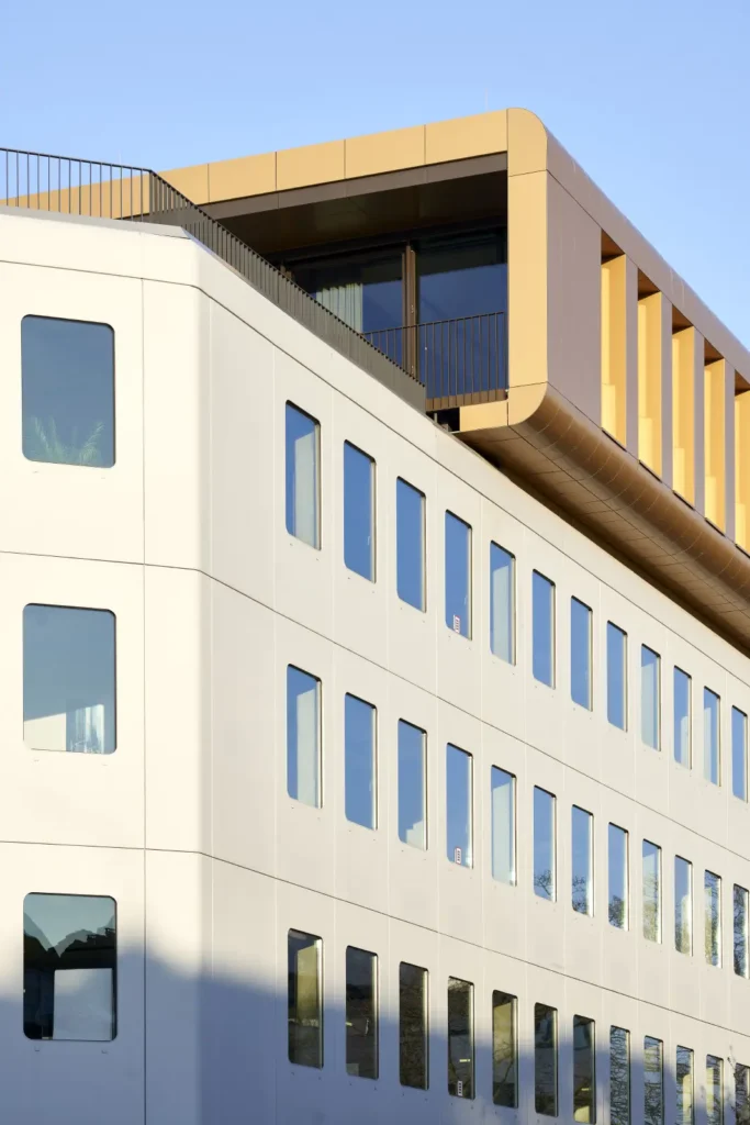 Gold rooftop extension contrasting with the white facade of Werft16 in Düsseldorf