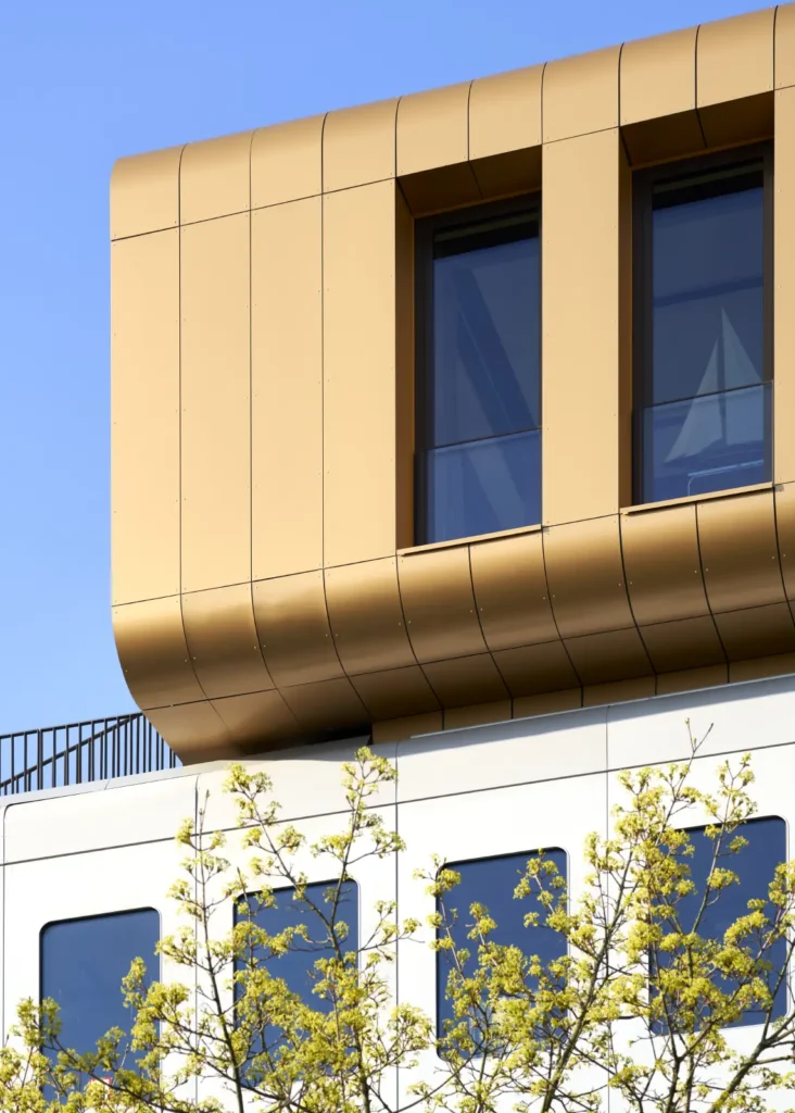 Corner detail of the gold-clad penthouse office at Werft16 by Kresings