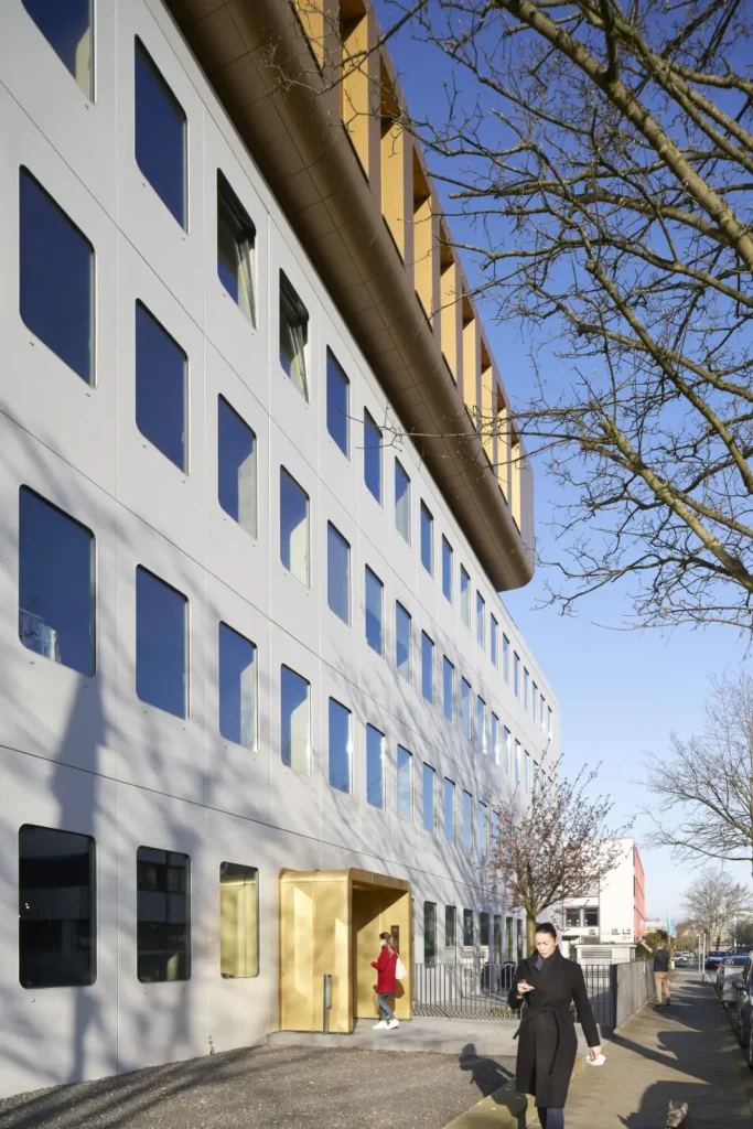 Pedestrians in front of Werft16 by Kresings with the gold upper storey visible in Düsseldorf