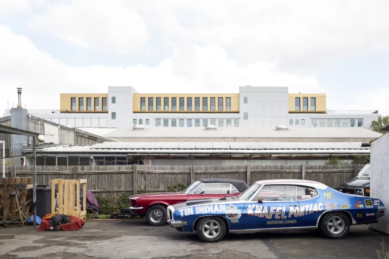 American cars and sleeping dog in front of Werft16 by Kresings with the gold upper storey visible in Düsseldorf