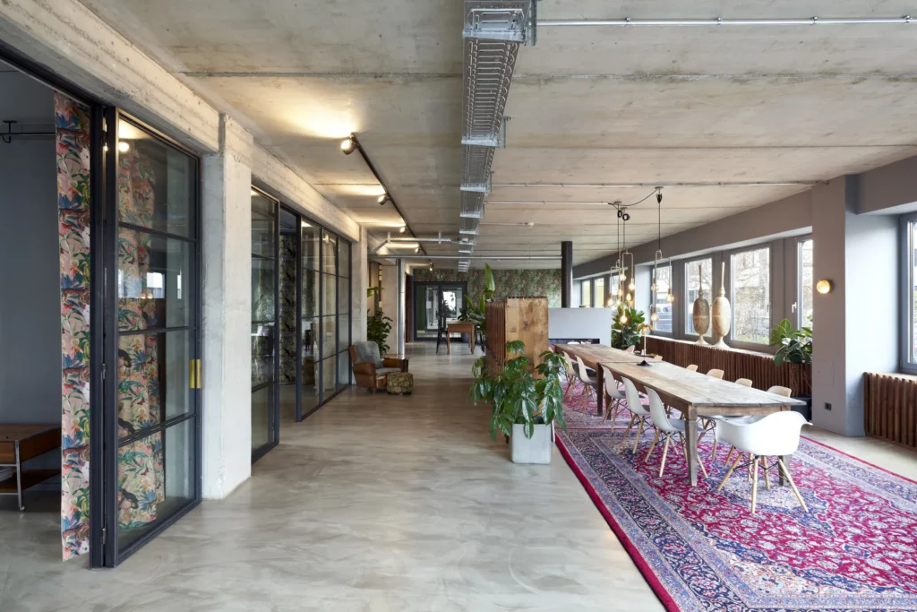 Open office space with Persian rug and industrial details at Werft16 by Kresings