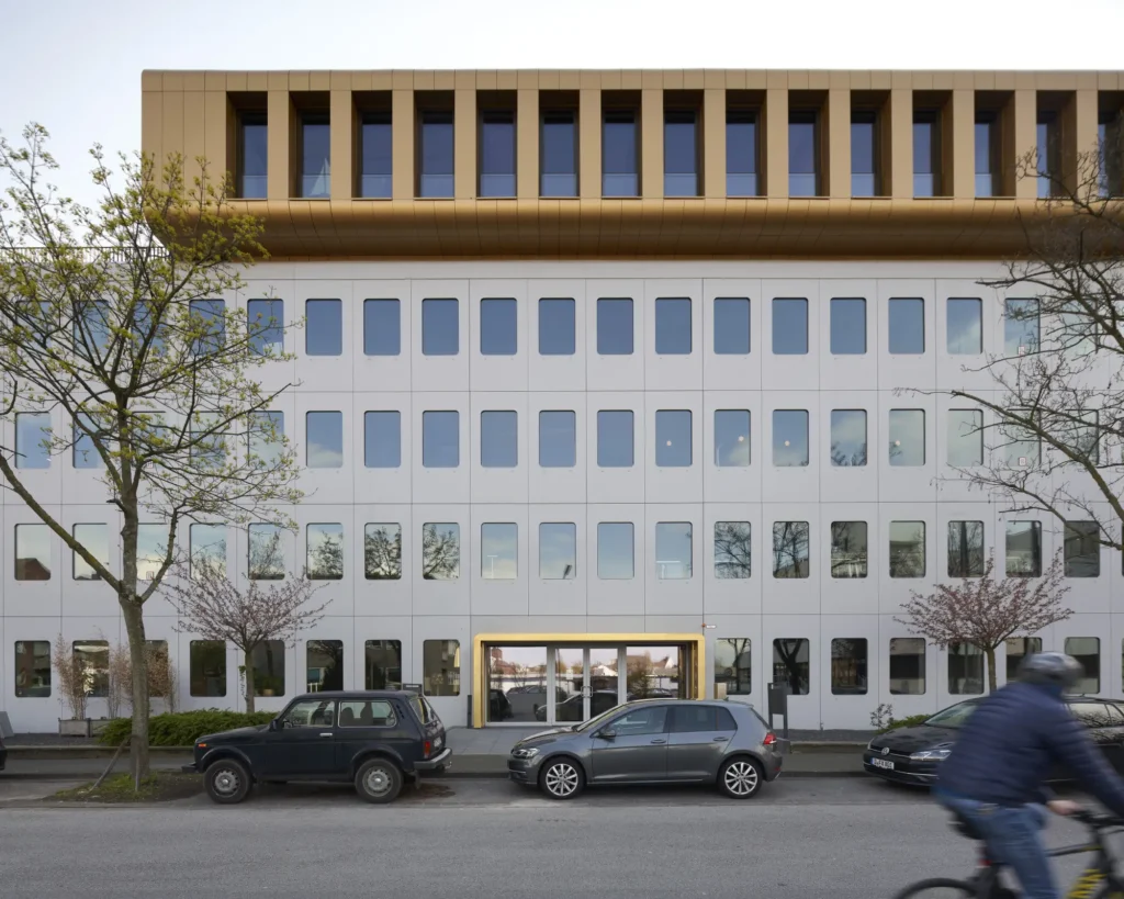 Cyclist passing the refurbished golden entry at Werft16 building by Kresings in Düsseldorf