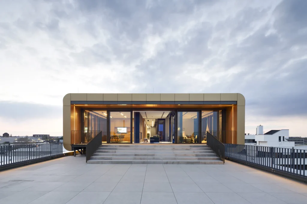 Illuminated entrance to the rooftop terrace of Werft16 at blue hour