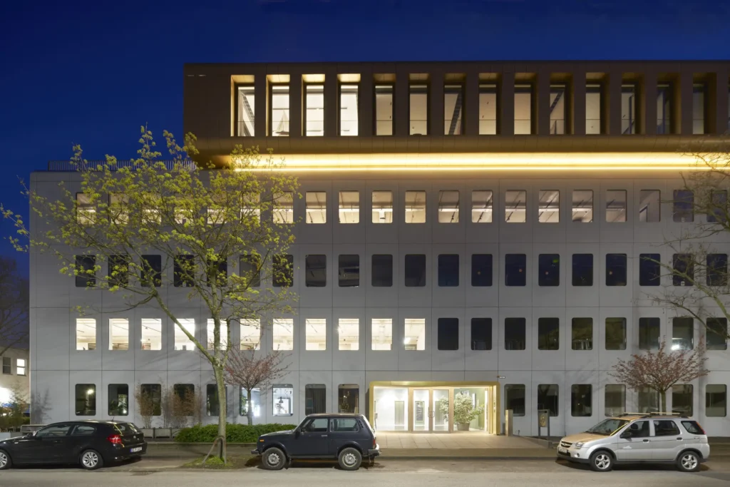 Gold-clad penthouse of Werft16 illuminated at night in Düsseldorf