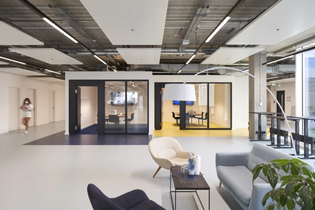 Reception area with grey seating and yellow floor accent at UP! Berlin entrance to sumup office