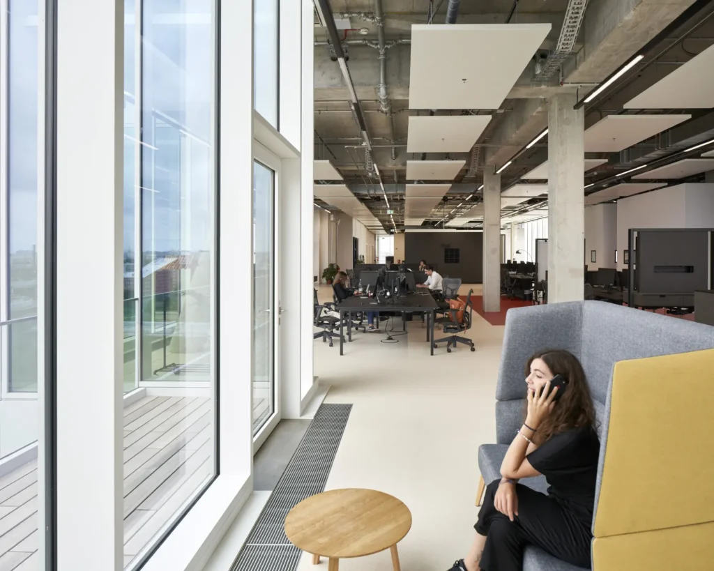 Coworking space with lounge seating and meeting rooms at UP! Berlin by Jasper Architects