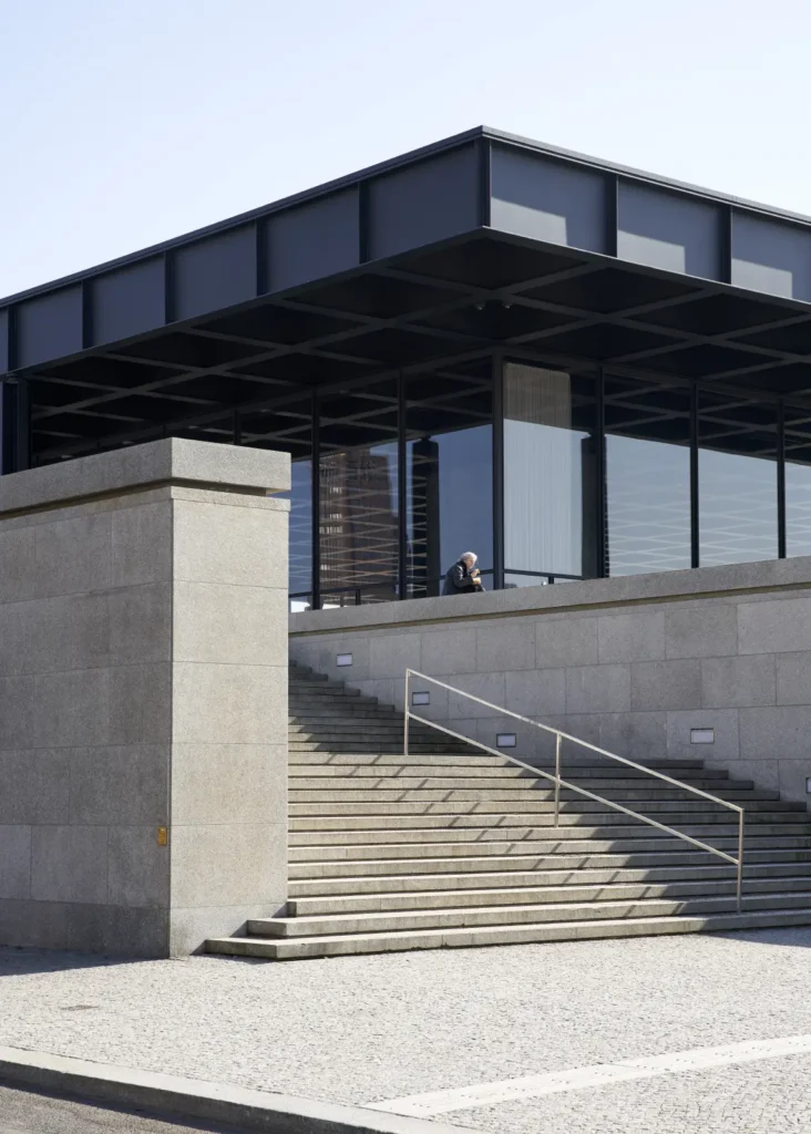 Man sitting on the podium of the Neue Nationalgalerie in Berlin by Mies van der Rohe, refurbished by David Chipperfield Architects