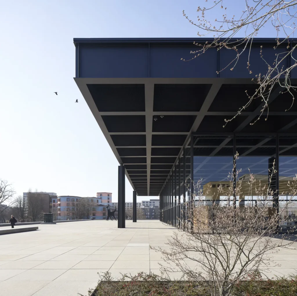 Edge of the floating steel roof at the Neue Nationalgalerie with bird and trees in Berlin