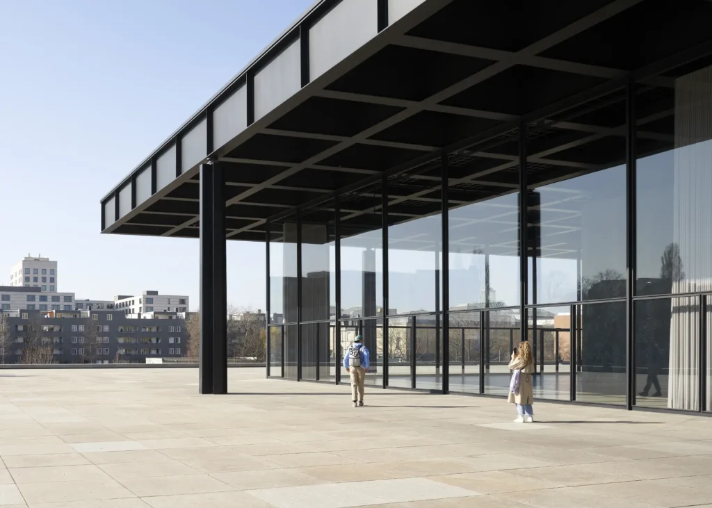 Woman taking a picture of the the floating steel roof and column detail at the Neue Nationalgalerie in Berlin