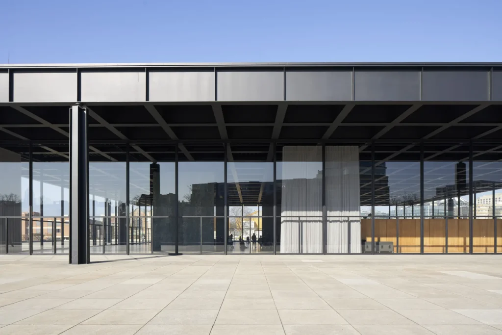 Glass facade of the Neue Nationalgalerie with exhibition curtains visible inside