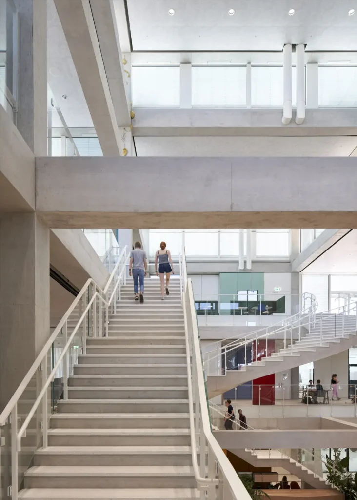 Students climbing the multi-storey central atrium of the SQUARE Learning Center by Sou Fujimoto in St. Gallen