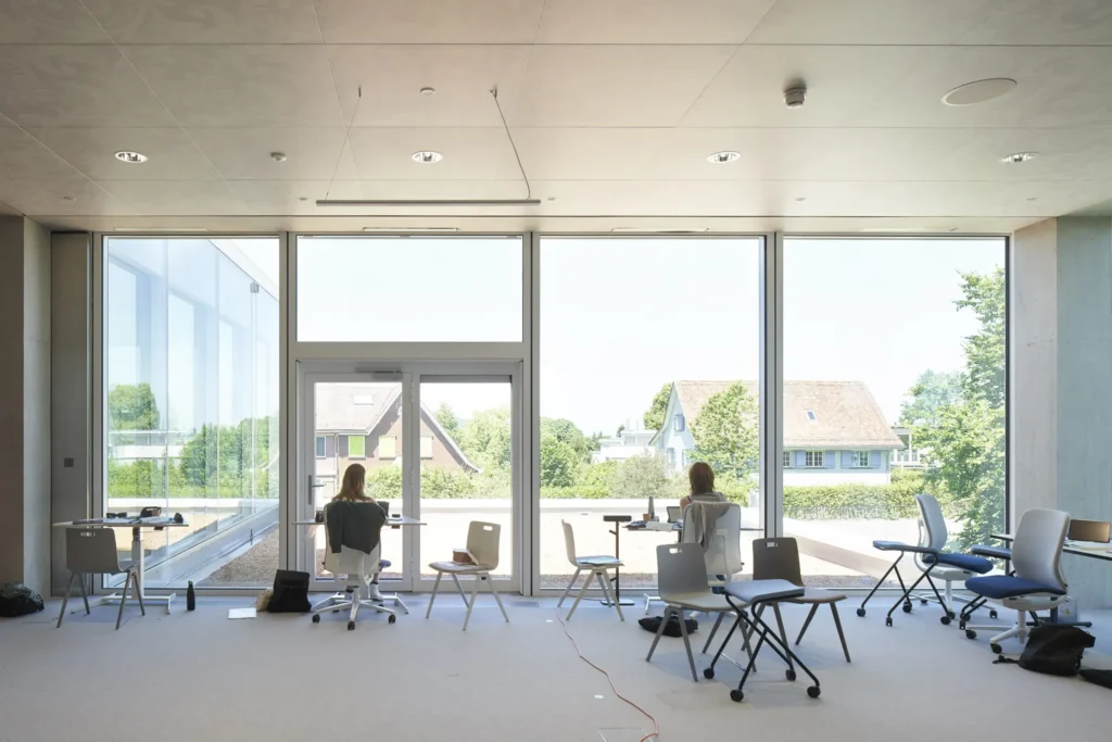 Students working at a window desk with views over the St. Gallen hills