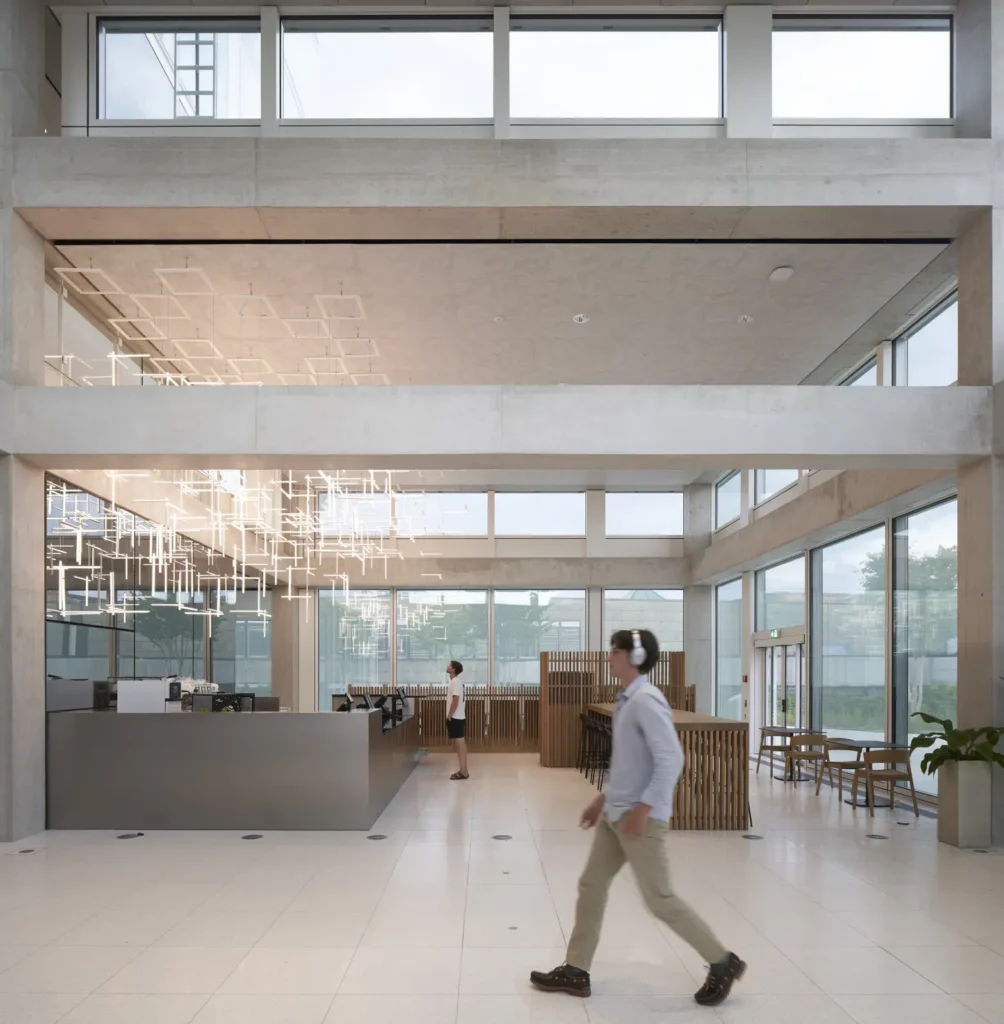 Geometric light installation on the ceiling of the SQUARE Learning Center in St. Gallen with student walking
