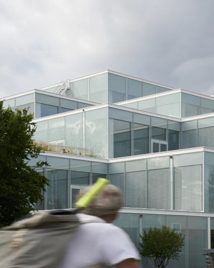 Man in front of glass facade detail of the SQUARE Learning Center by Sou Fujimoto in St. Gallen