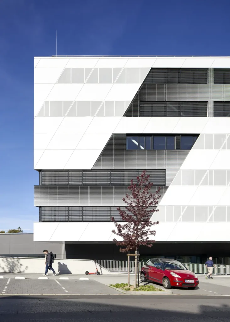 People walking in front of abstract facade with angled window strips at the KMAC by studioMDA