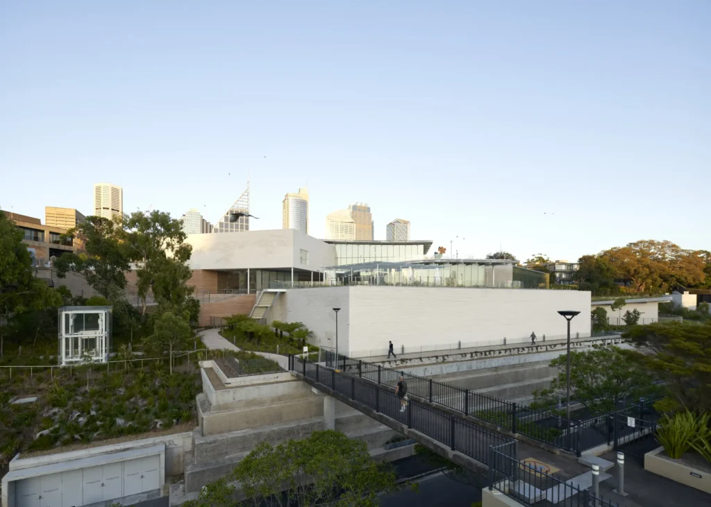 Sydney Modern by SANAA nestled into hillside with green roof and Sydney skyline behind