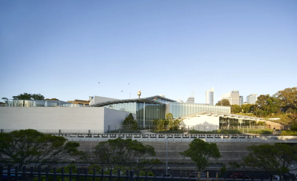 Sydney Modern by SANAA nestled into hillside with green roof and Sydney skyline behind