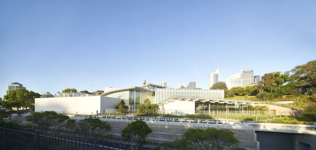 Sydney Modern by SANAA nestled into hillside with green roof and Sydney skyline behind