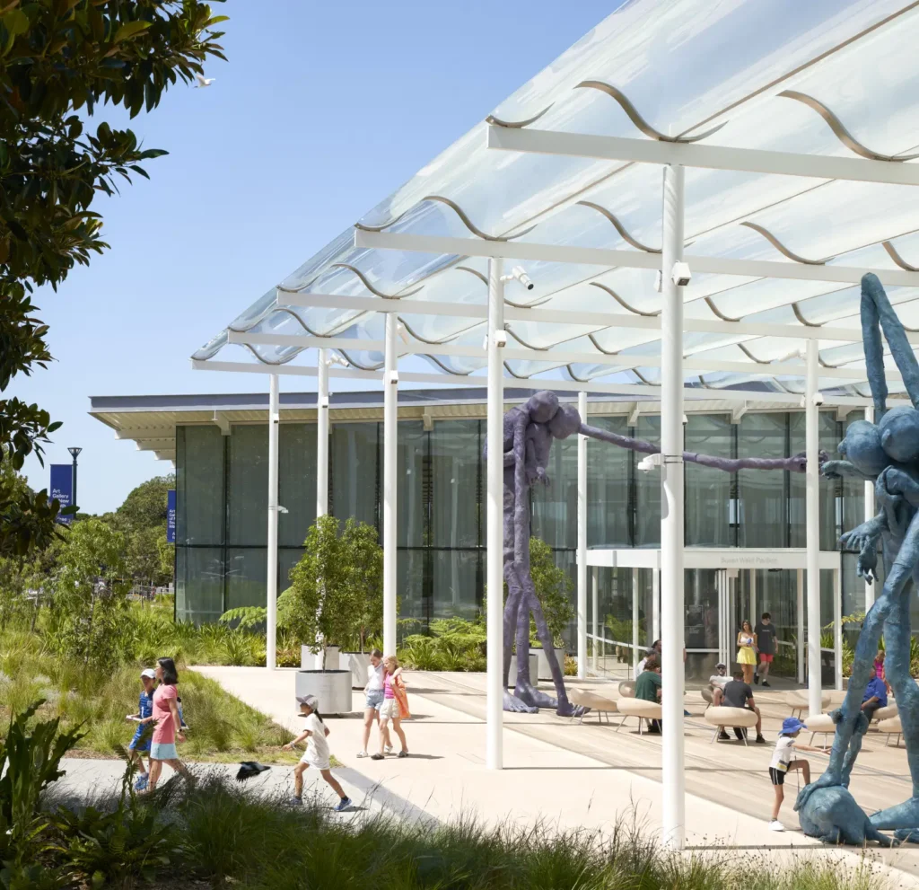 Entrance plaza of Sydney Modern extension of the Art Gallery of New South Wales with families and glass pavilion behind