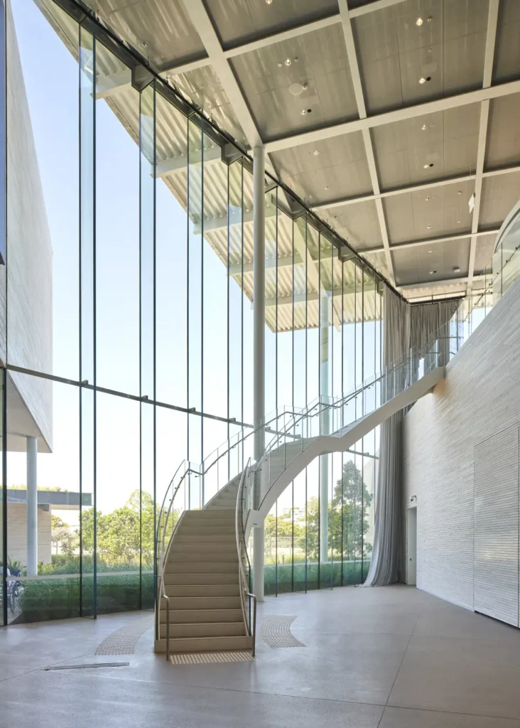 Multi-level interior with sloping staircase and glass walls at Art Gallery of New South Wales extension