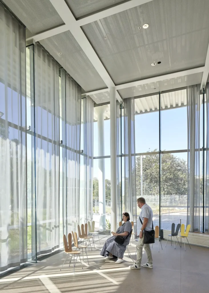 People seated at full-height glazing of Sydney Modern gallery by SANAA