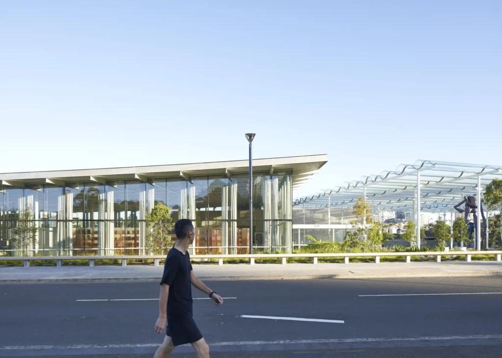 Man looking at the glass and steel pavilion of Sydney Modern art gallery with cantilevered roof