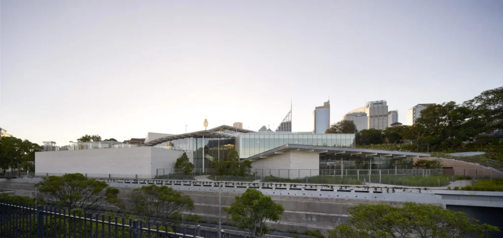 Distant view of Sydney Modern pavilions set among parkland with city behind
