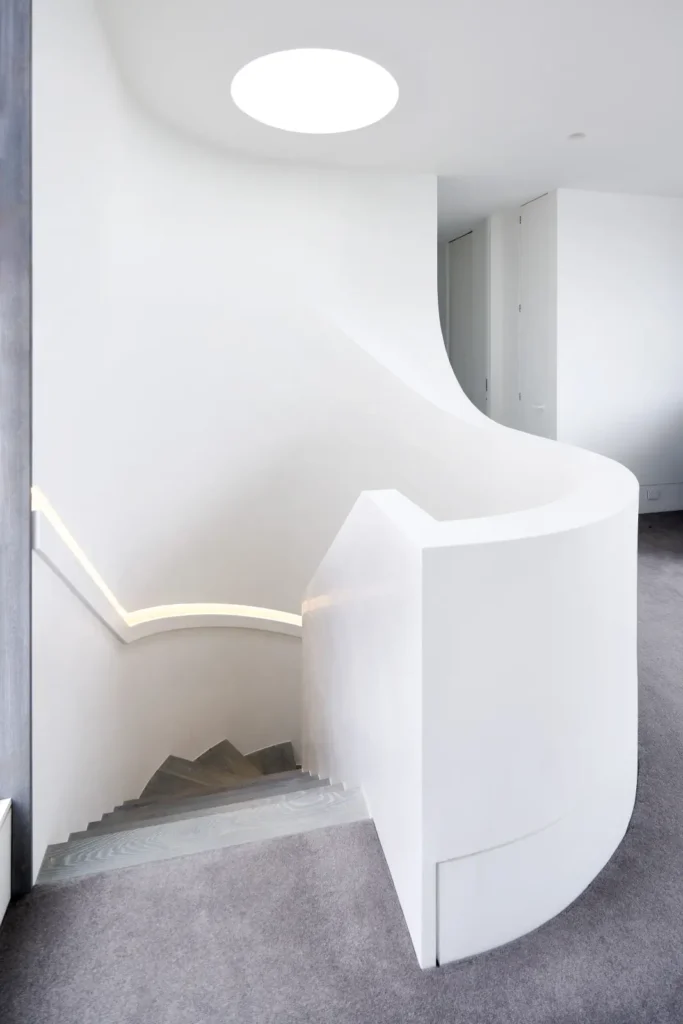 Circular skylight casting natural light into white interior at Alexandra Street house Melbourne