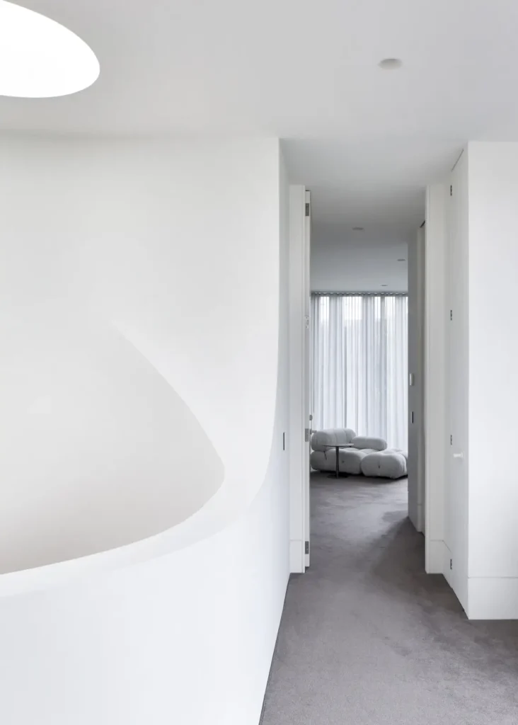 Light-filled corridor with sculptural curved wall at Alexandra Street by Megowan Architectural