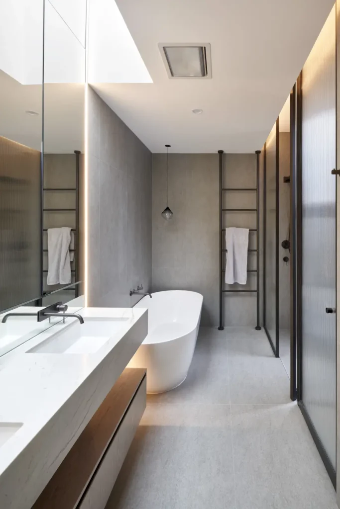Minimalist bathroom with freestanding bathtub and double vanity at Alexandra Street by Megowan Architectural