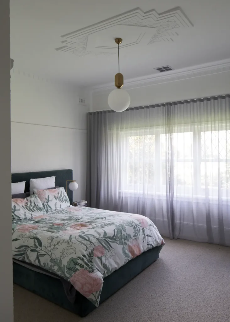 Master bedroom with floral bedding and original decorative ceiling at Lindsay by Megowan Architectural