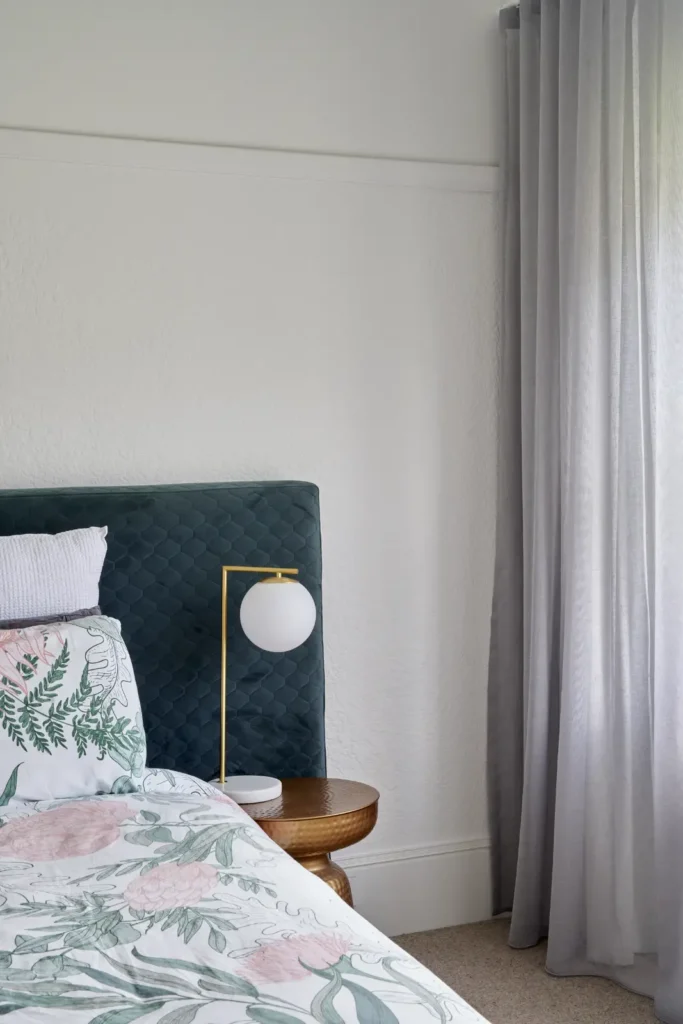 Bedroom with ornate Art Deco ceiling moulding and teal upholstered headboard at Lindsay house