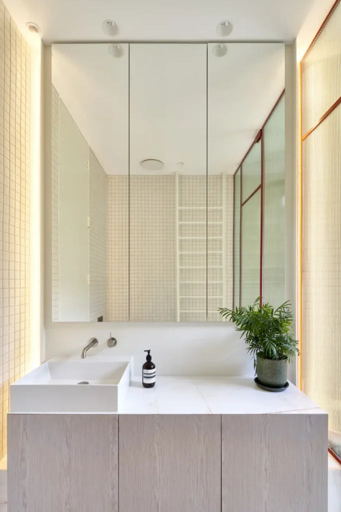 Illuminated vanity bathroom detail with mirror and frosted glass at Lindsay renovation