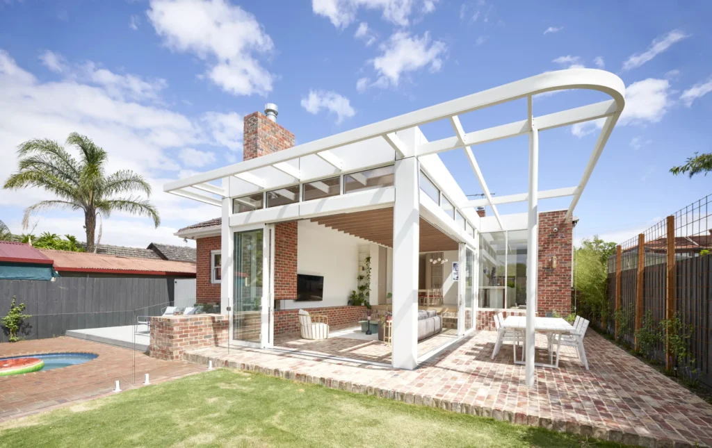 Rear view of Lindsay house extension with steel pergola and brick paving by Megowan Architectural