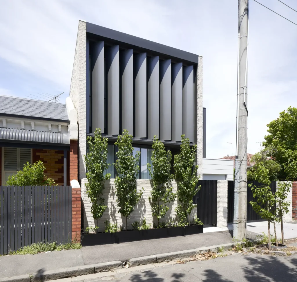 Street view of Alexandra Street residence with operable metal louvers and brick base in Melbourne