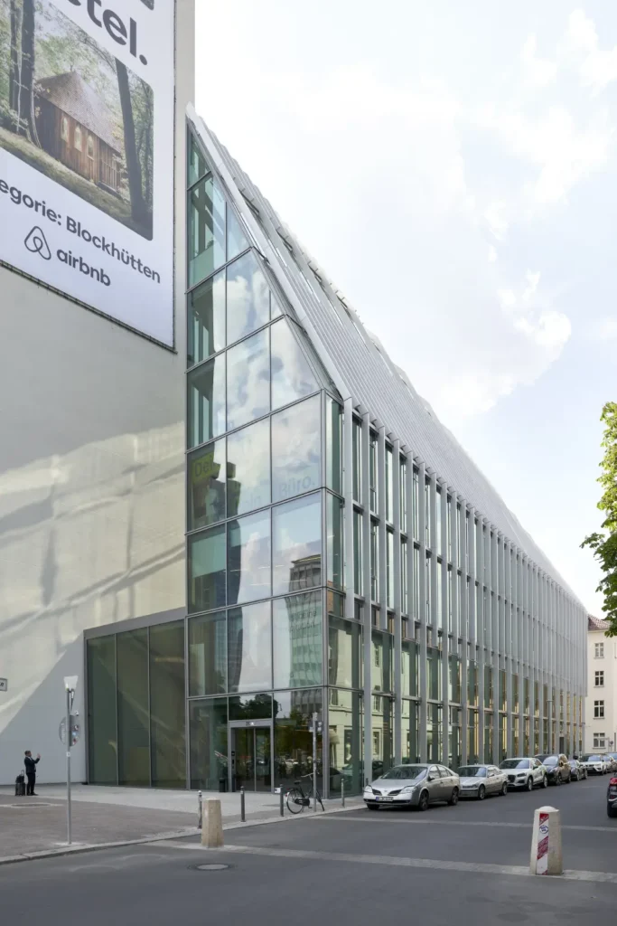 Podium building with vertical glass fins at Pressehaus am Alexanderplatz by GMP Architects